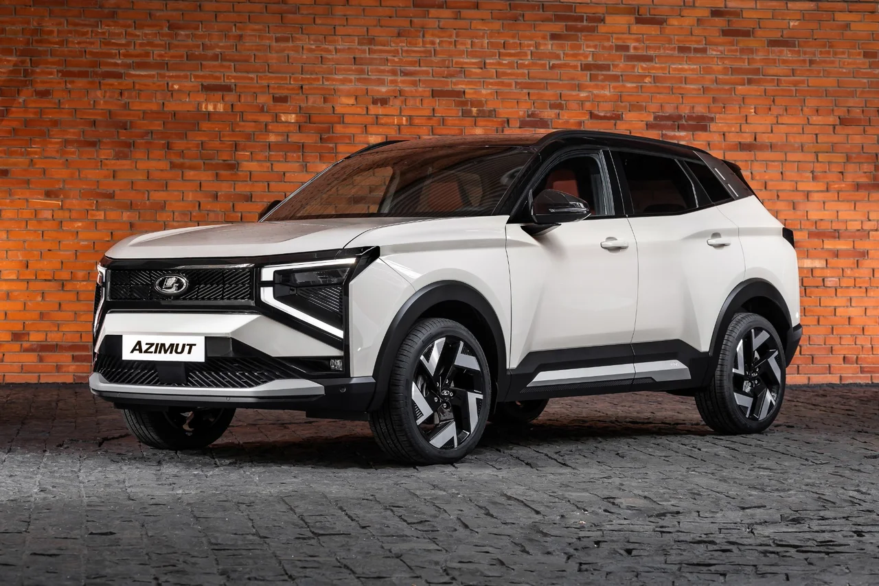 Белый Lada Azimut с чёрной крышей на фоне кирпичной стены, вид спереди-сбоку